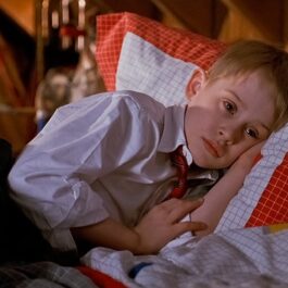 Macaulay Culkin, imagini din filmul Singur acasă, în timp ce stă în pat, trist