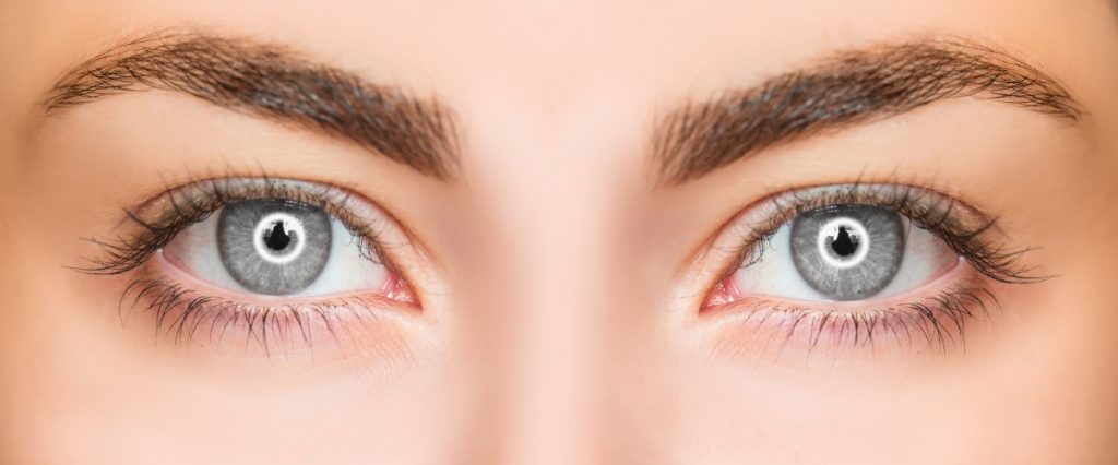 O femeie cu ochii albaștri are gene false aplicate discret și sprâncenele conturate sunt încadrate perfect în restul feței.