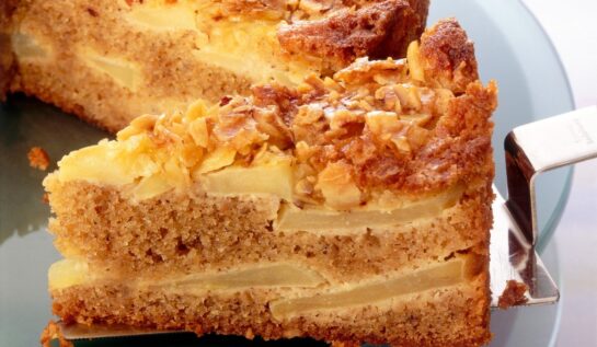 Prăjitură de post cu mere și nuci, feliată pe o spatulă de tort
