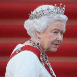 Regina Elisabeta purtând o tiara și un set de bijuterii îmbrăcată într-un costum alb la un banchet din Berlin