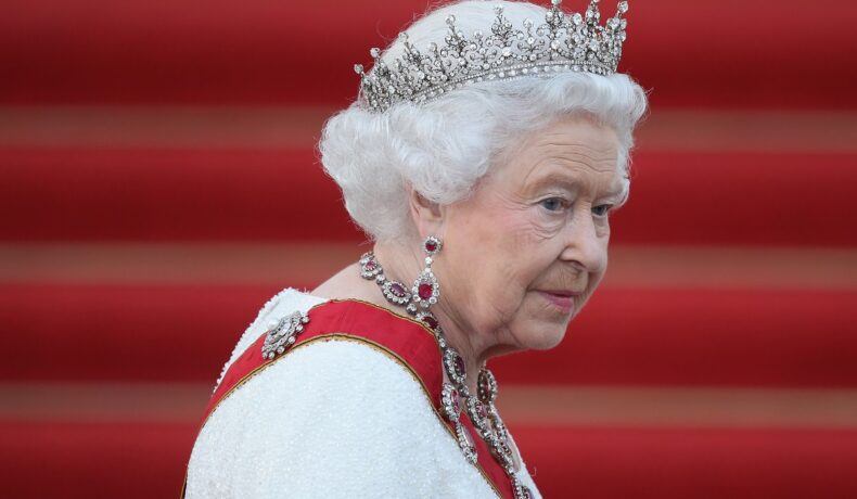 Regina Elisabeta purtând o tiara și un set de bijuterii îmbrăcată într-un costum alb la un banchet din Berlin
