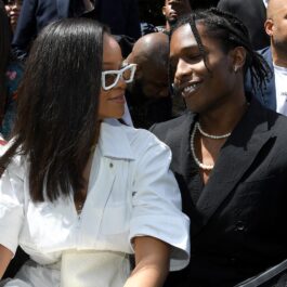 Rihanna îmbrăcată într-o ținută albă în timp ce îl privește pe rapper-ul Asap Rocky la Paris Fashion Week în anul 2018