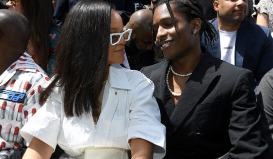 Rihanna îmbrăcată într-o ținută albă în timp ce îl privește pe rapper-ul Asap Rocky la Paris Fashion Week în anul 2018