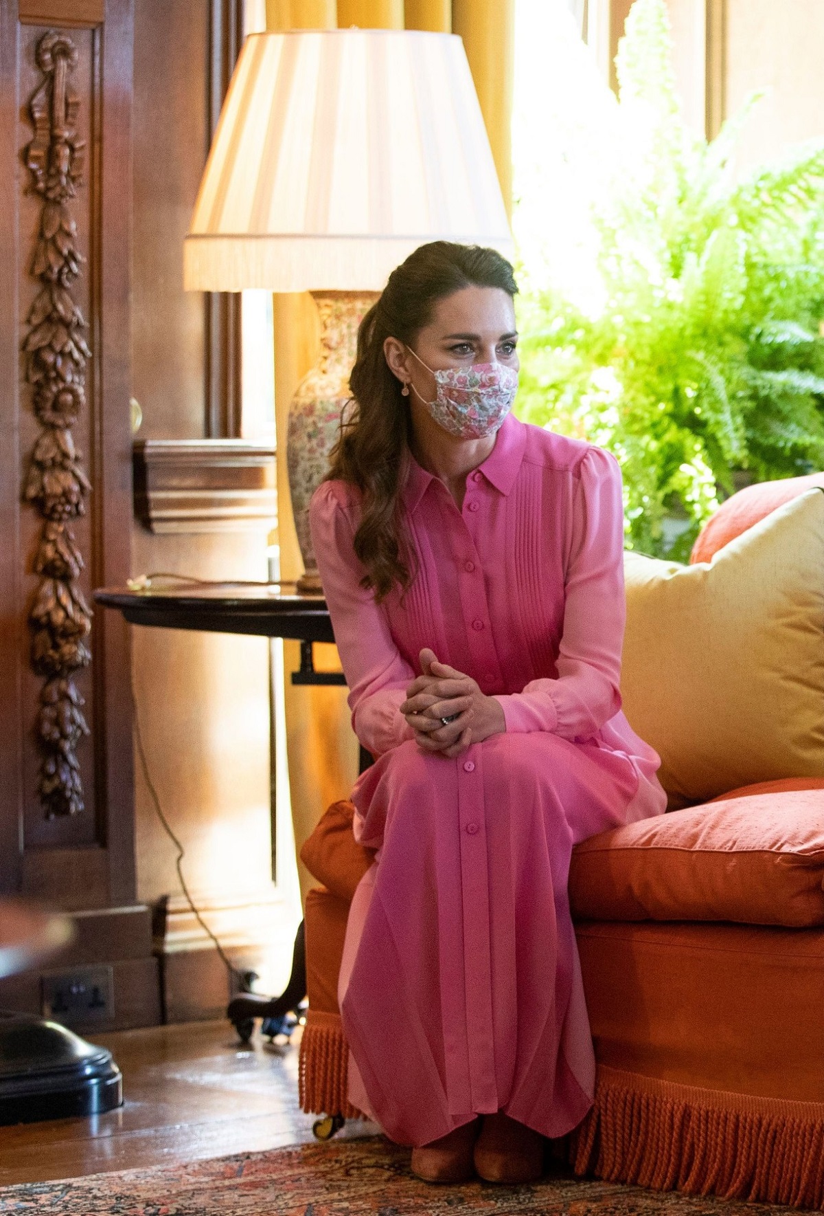 Ducesa Kate Middleton în rochie roz în timp ce stă pe o canapea portocalie cu masca pe față la întâlnirea de la palatul Holyroodhouse