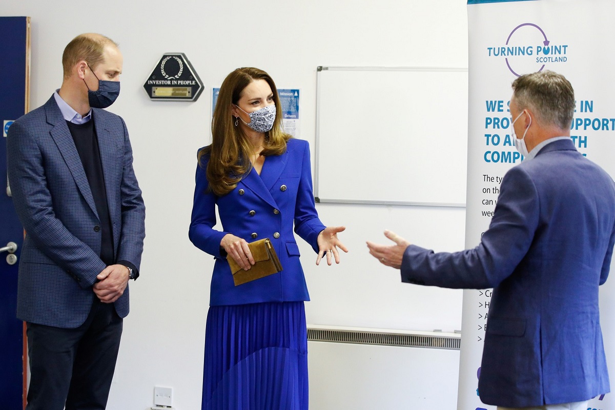 Kate Middleton îmbrăcată într-o ținută monocromă albastră alături de soțul ei Prințul william în timp ce discută cu Neil Richardson la o întâlnire oficială din Scoția