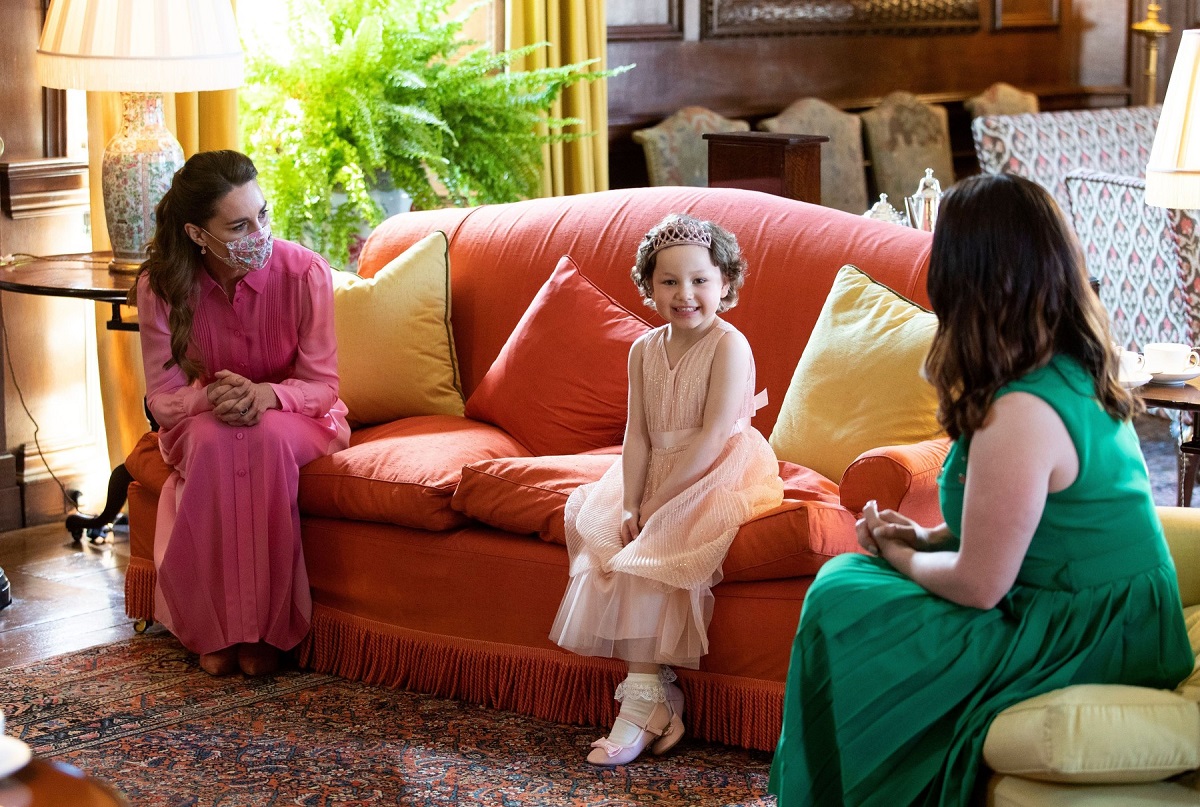 Ducesa Kate Middleton în rochie roz pe canapea lângă Mila Sneddon și mama sa la Palatul Holyroodhouse