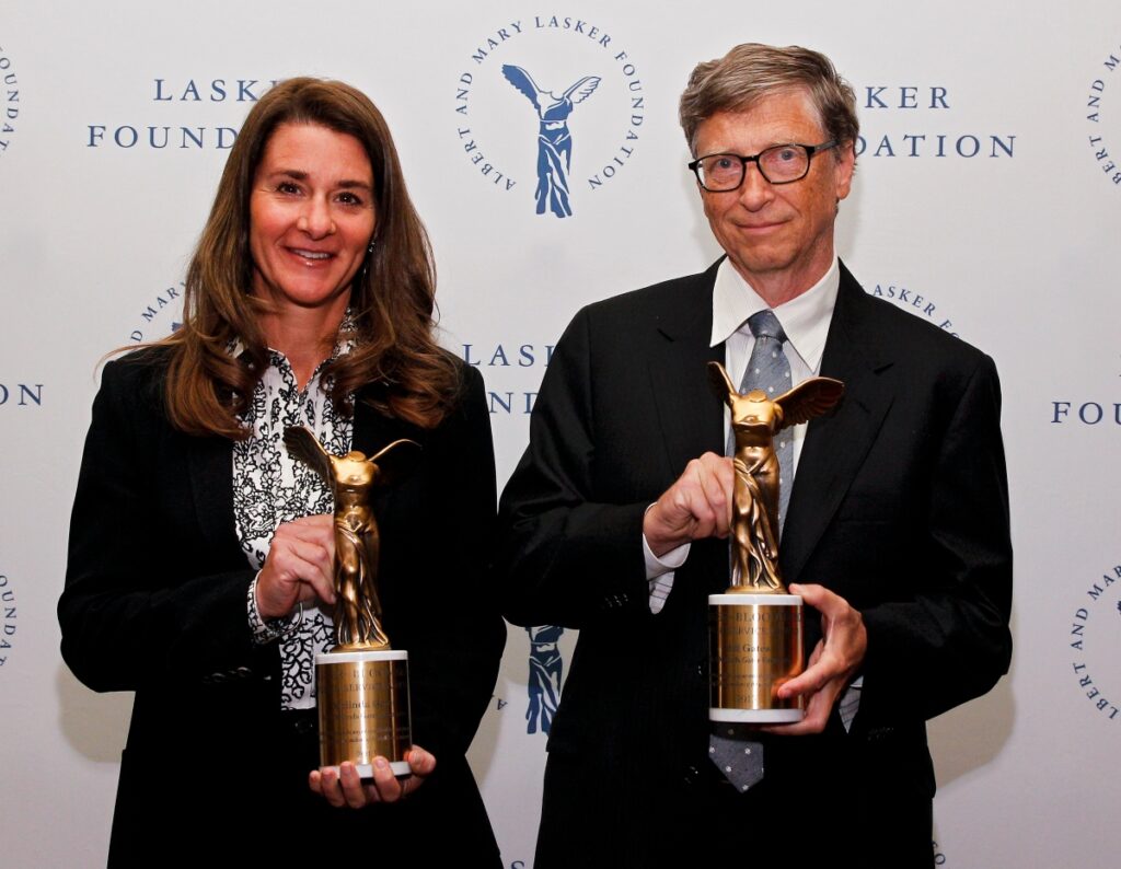 Bill Gates alături de soția lui. Ambii țin în mână câte un trofeu câștigat pentru activitatea lor filantropică.