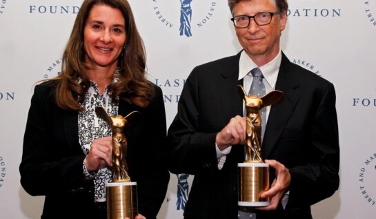 Bill Gates alături de soția lui. Ambii țin în mână câte un trofeu câștigat pentru activitatea lor filantropică.
