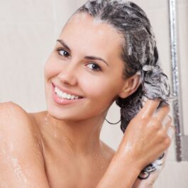 O femeie în duș se spală de cap