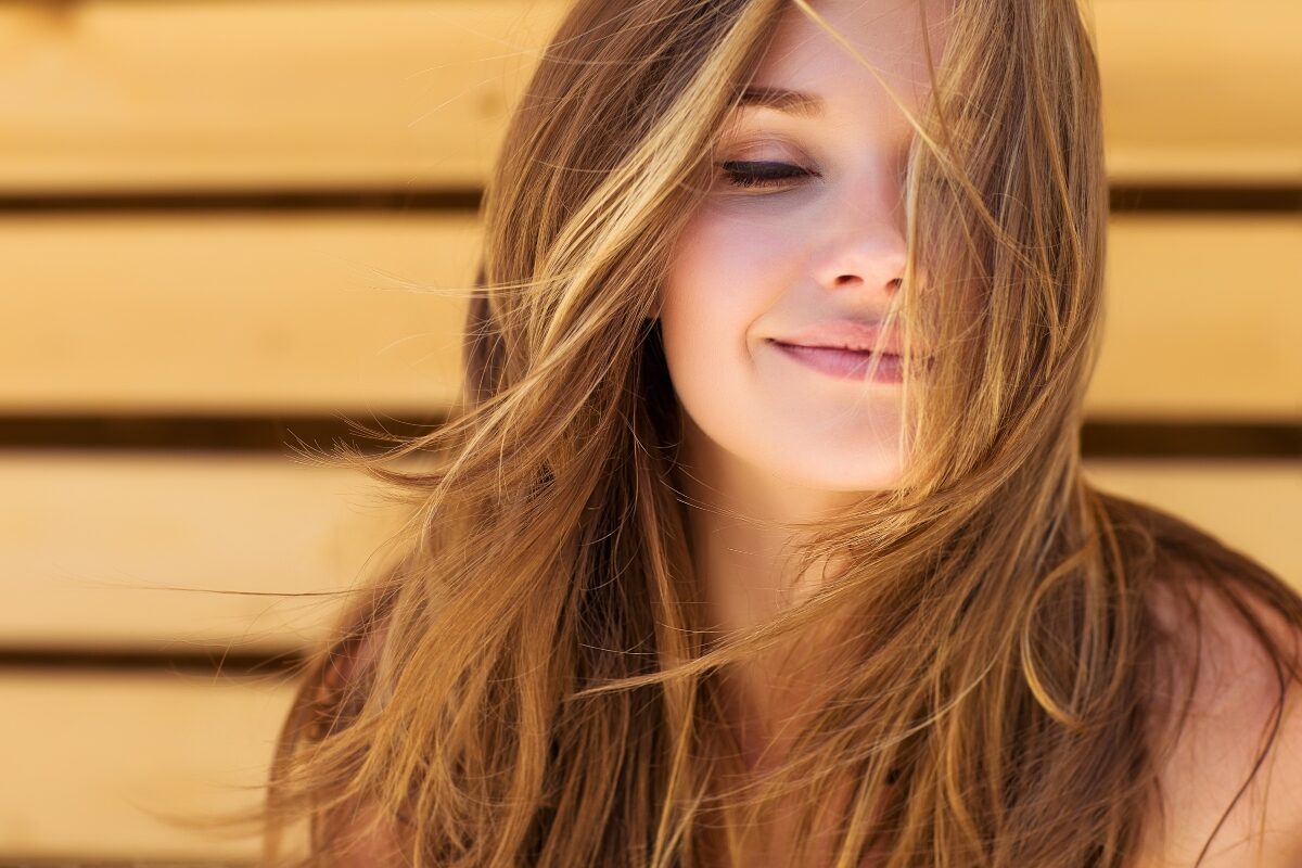 O femeie cu păr lung zâmbește.