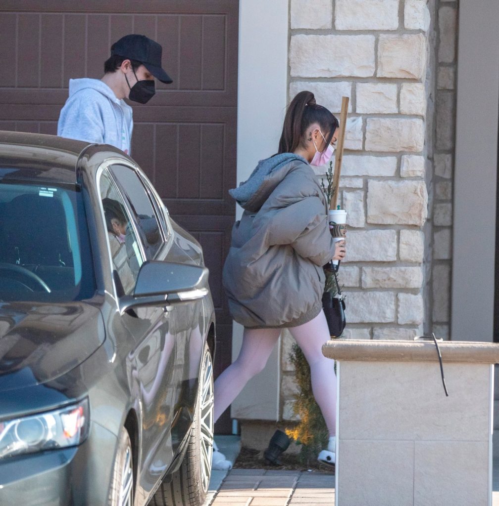 Ariana Grade și Dalton Gomez, în timp ce se feresc de fotografi și intră în casa unor prieteni