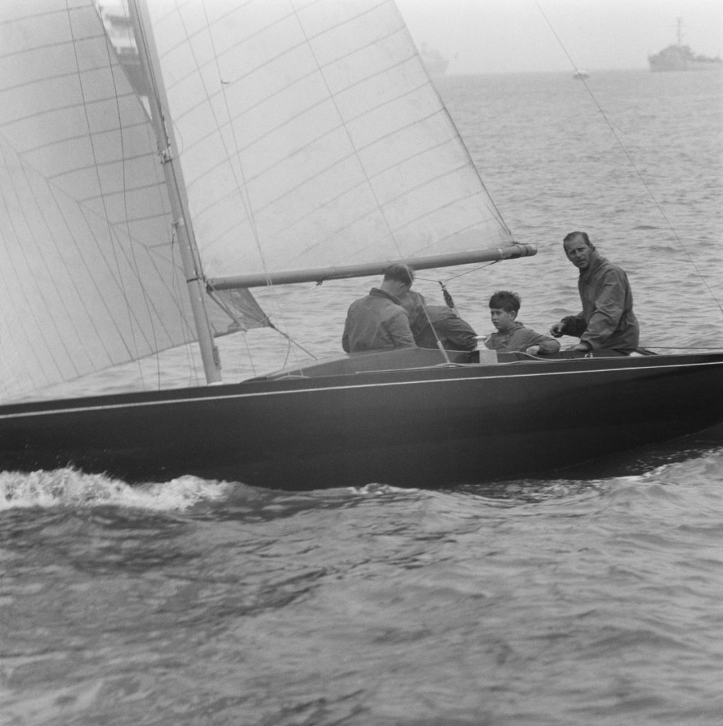 O poză alb-negru cu Prințul Philip și fiul său într-o barcă.