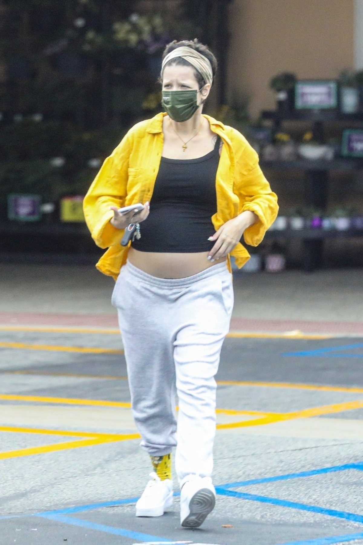 Halsey însărcinată este îmbrăcată sport cu o bluză galbenă , cu un top negru și nu pantaloni gri. Pantofii sport sunt albi. PE față are o mască neagră și părul strâns la spate