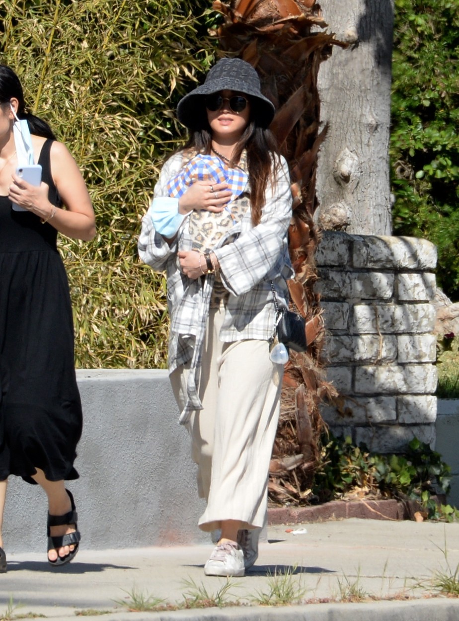 Brenda Song, partenera lui Macaulay Culkin, la plimbare, cu bebelușul în marsupiu