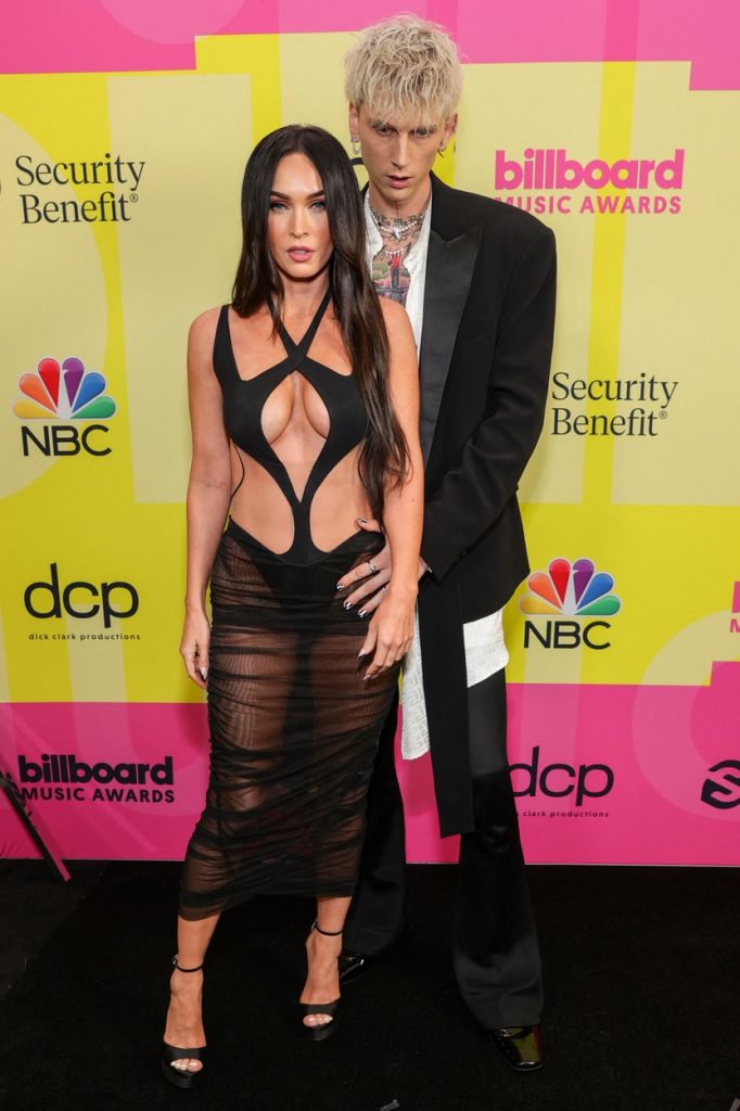 Megan Fox și Machine Gun Kelly, în timp ce stau îmbrățișați, pe covorul roșu la Premiile Billboard 2021