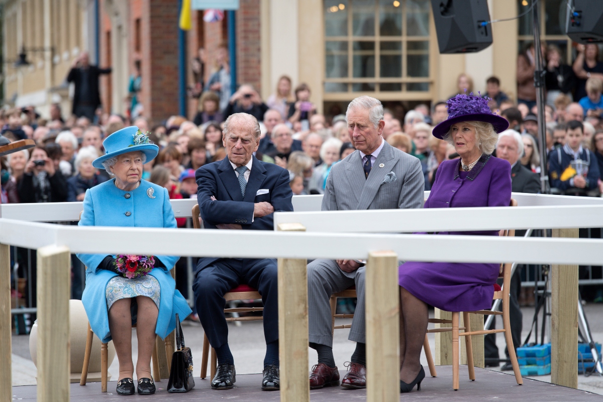 În imagine stau la aceeași masă Regina Elisabeta, Prințul Philip, Prințul Charles și Camilla, Ducesă de Cornwall. Toți sunt îmbrăcați foarte elegant.