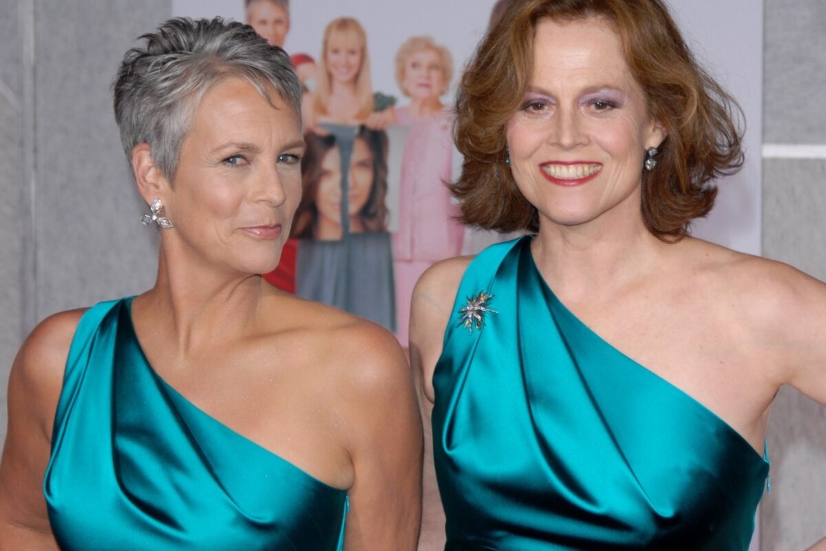 Jamie Lee Curtis și Sigourney Weaver, poartă aceeași rochie de culoare verde, cu umărul gol. Sunt coafate și machiate discret ambele
