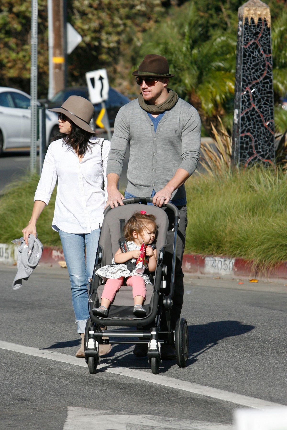 Jenna Dewan într-o blouză albă cu blugi și pălărie alături de soțul ei Channing Tatum în timp ce o plimbă în căruț pe fiica lor Everly
