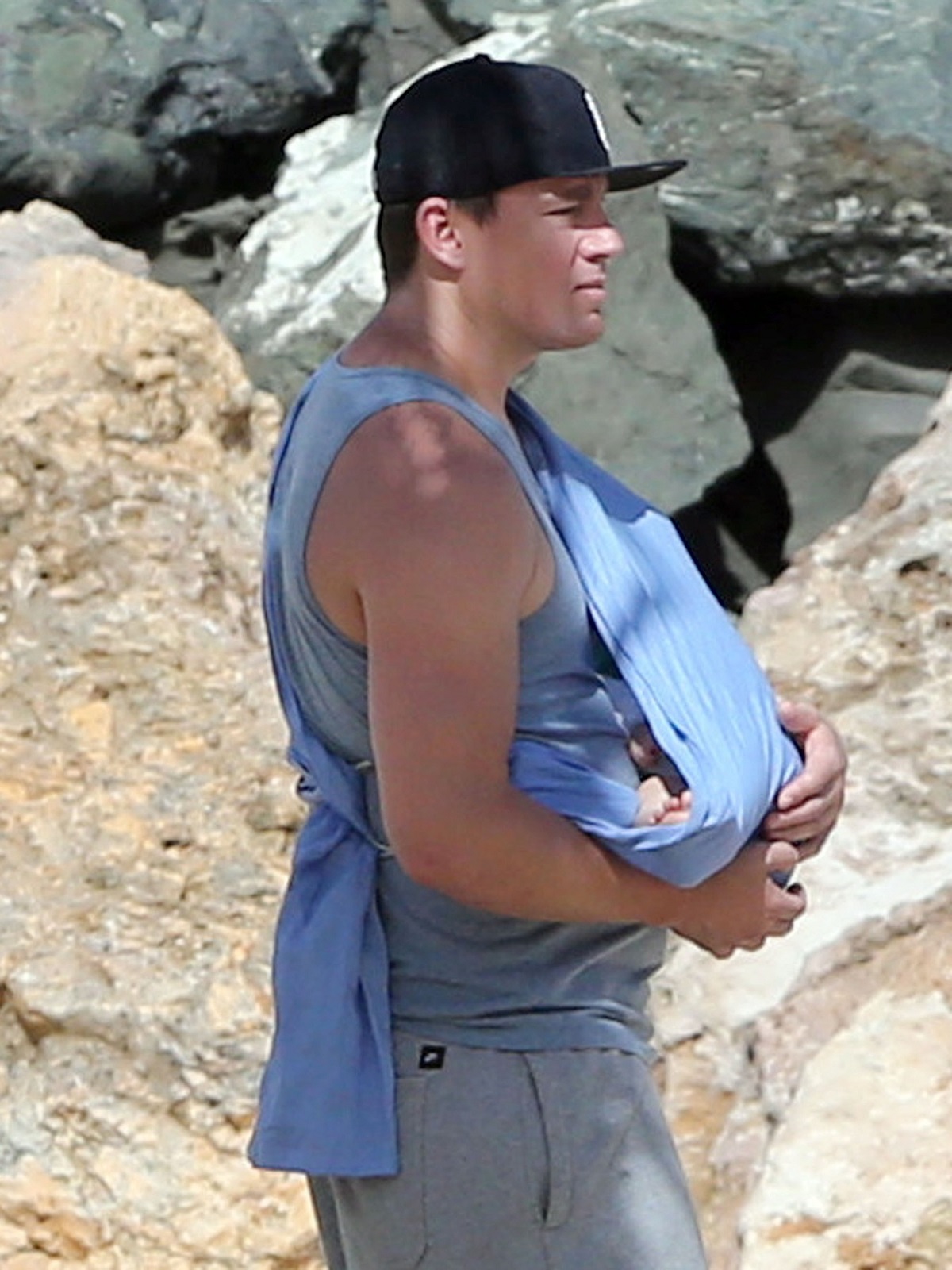 Actorul Channing Tatum pe plajă îmbrăcat într-o bluză albastră în timp ce își ține în brațe fiica