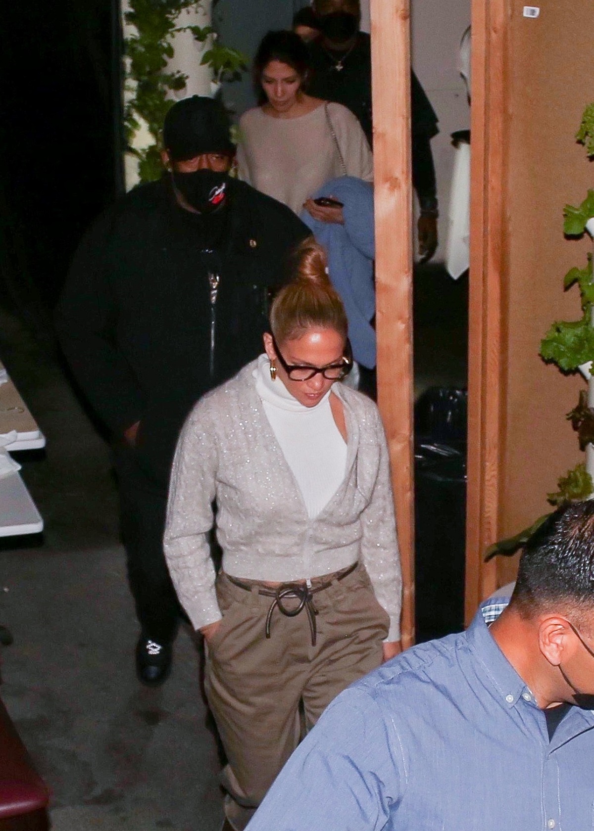 Jennifer Lopez purtând o bluză gri și o pereche de pantaloni maro, în timp ce părăsește restaurantul unede a luat cina cu sora sa