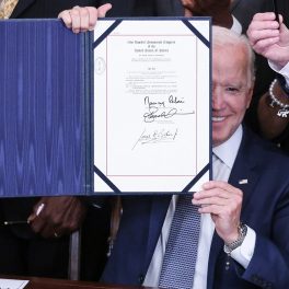 Președintele Joe Biden în timp ce ține în mână actul care stabilește că Juneteenth va fi zi de sărbătoare națională