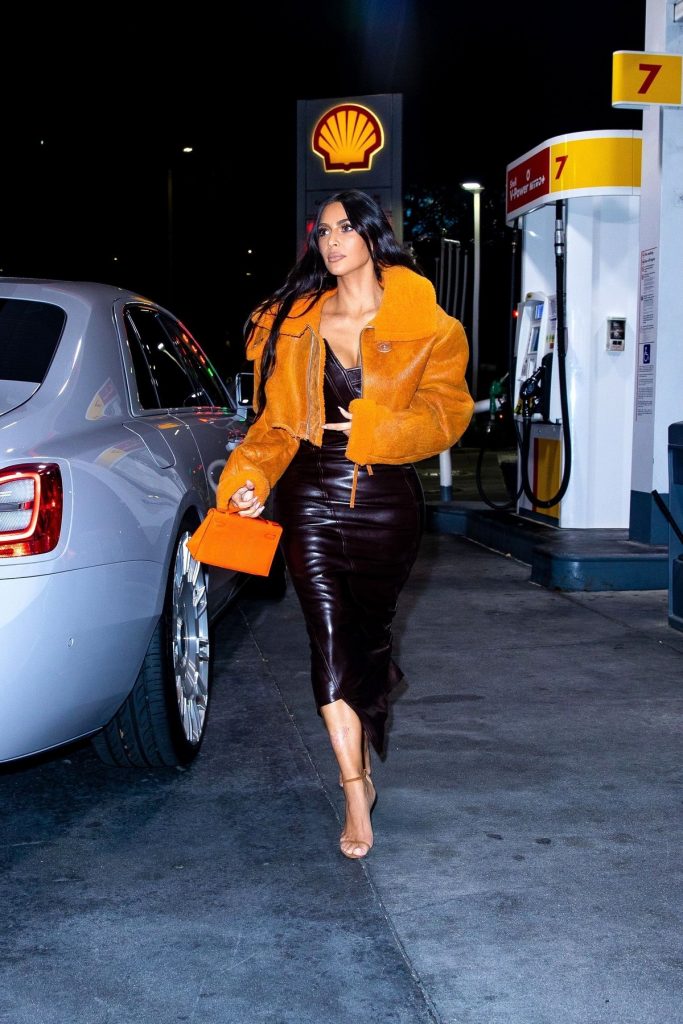 Kim Kardashian a purtat o jachetă orange de la un brand deținut de Kanye West la care a asortat o rochie din piele neagră și o pereche de tocuri nude în timp ce a făcut cumpărături într-o parcare din Los Angeles