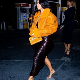 Kim Kardashian mergând la cumpărături într-o parcare din Los Angeles în timp ce poartă o rochie mulată de piele neagră și o jachetă de la un brand deținut de Kanye West