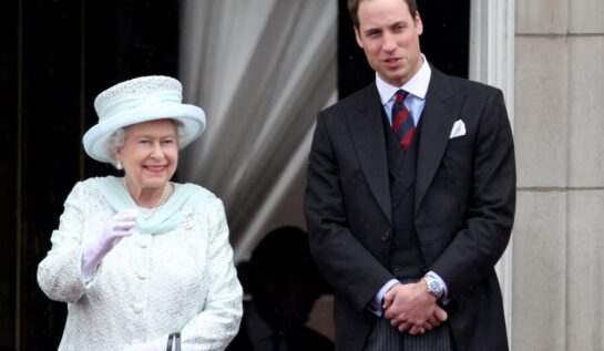 Regina Elisabeta îmbrăcată într-un costum alb cu pălărie de aceeași culoare, alături de nepotul său, Prințul William, în timp ce salută mulțimea de la balcon în cadrul Jubileului de Diamant când PRințul i s-a adresat Majestății Sale cu numele special de alint al Reginei Elisabeta