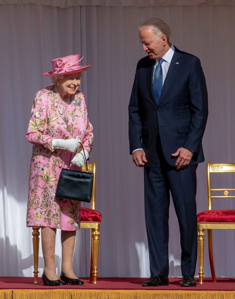Regina Elisabeta într-o rochie roz cu imprimeu floral alături de Președintele statelor Unite ale Americii, Joe Biden, îmbrăcat la costum, la întâlnirea lor oficială de la castelul Windsor