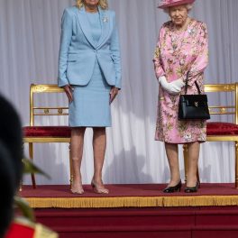 Regina Elisabeta într-o rochie roz cu imprimeu floral pe scenă alături de Prima Doamnă a Statelor Unite ale Americii Jill Biden la întâlnirea oficială ținută la Castelul Windsor