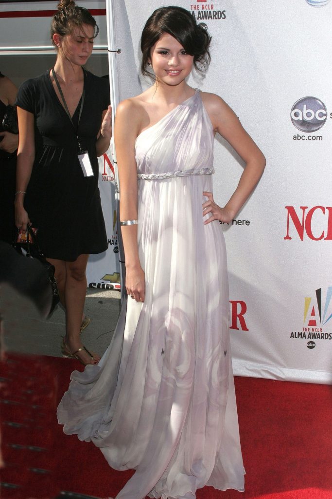 Selena Gomez cu părul strâns într-un coc și purtând o rochie albă vaporoasă dezvăluie secretul unei ținute perfecte pe covorul roșu în cadrul Premiilor ALMA care s-au derulat în 2008
