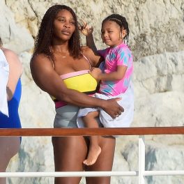Serena Williams în costum de baie colorat în timp ce o ține în brațe pe fiica sa, Olympia și sunt fotografiate de soțul sportivei Alexis
