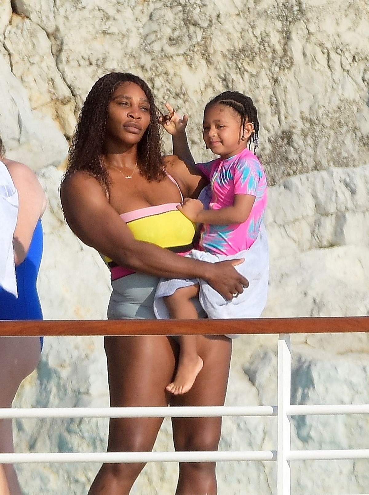 Serena Williams în costum de baie colorat în timp ce o ține în brațe pe fiica sa, Olympia și sunt fotografiate de soțul sportivei Alexis