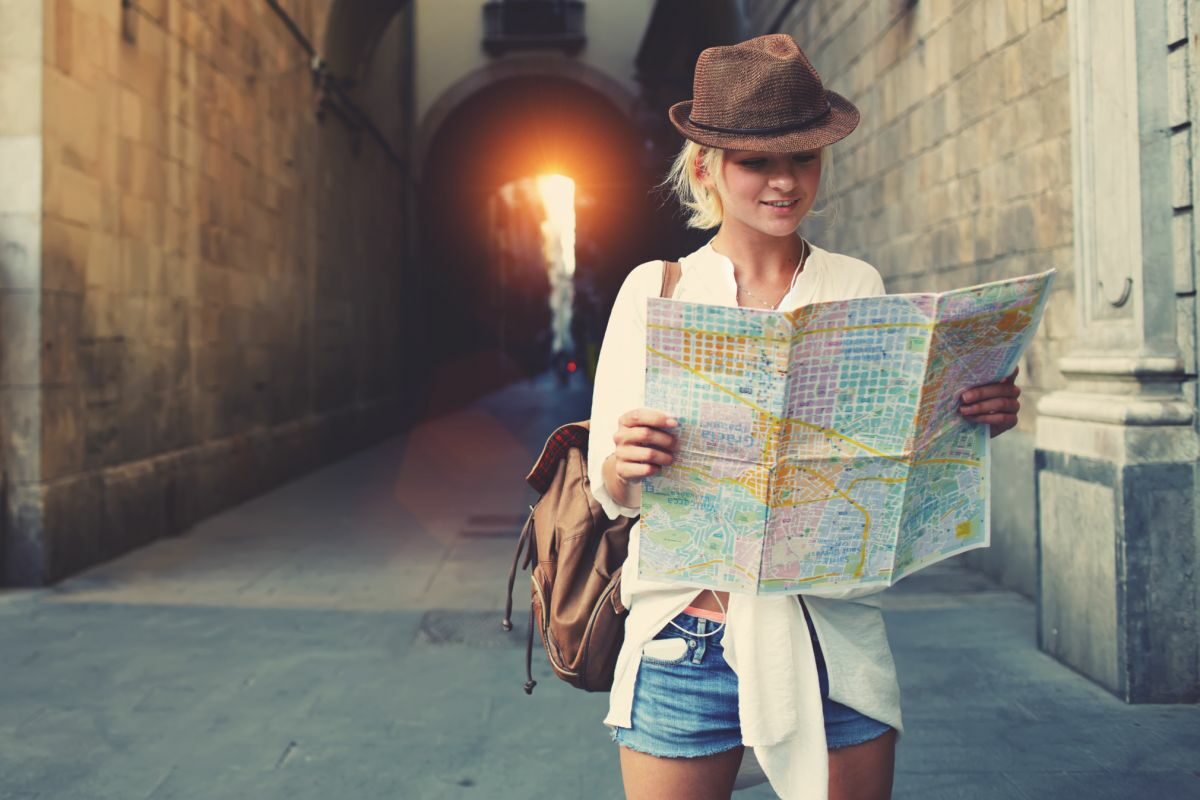O turistă care încearcă să descopere următorul obiectiv, analizând harta geografică