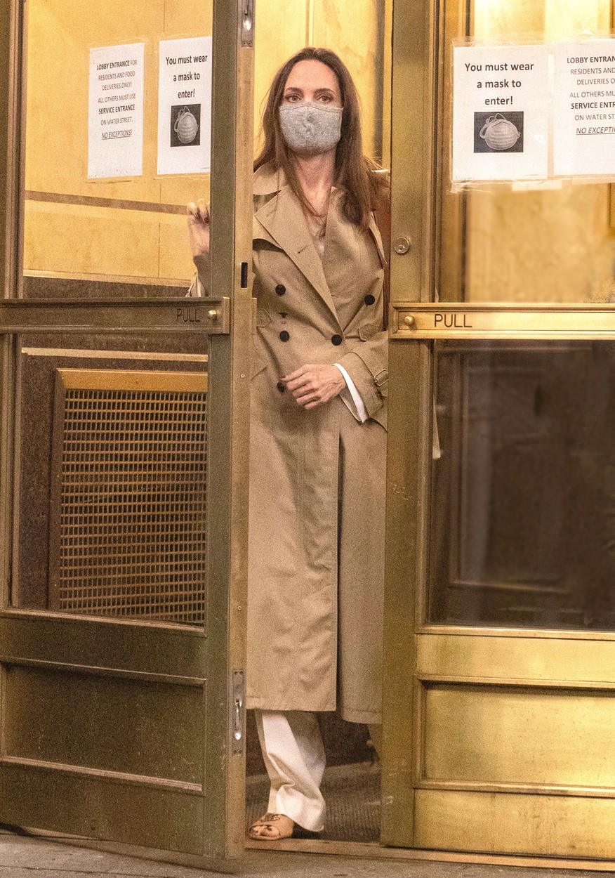 Angelina Jolie, îmbrăcată într-un pardesiu lung, bej, în Brooklyn, în timp ce iese dintr-o clădire