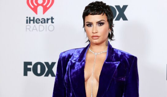 Demi Lovato aparut într-un costum albastru dupa ce a dezvaluit ca e non-binara, cu decolteu, fundal alb, la evenimentul iHeartRadio Music Awards din mai 2021