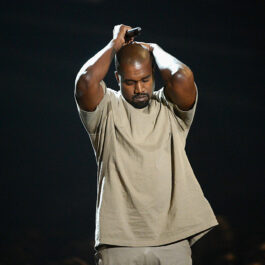 Kanye West, pe scenă, la MTV Video Music Awards, în 2015, cu mâinile în cap