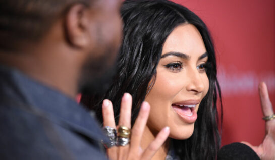 Kim Kardashian, la un eveniment monden în 2019, cu mâinile în sus, exprimând o mirare