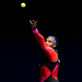 Serena Williams, pe terenul de tenis la Australian Open, în timp ce lovește mingea cu racheta de tenis