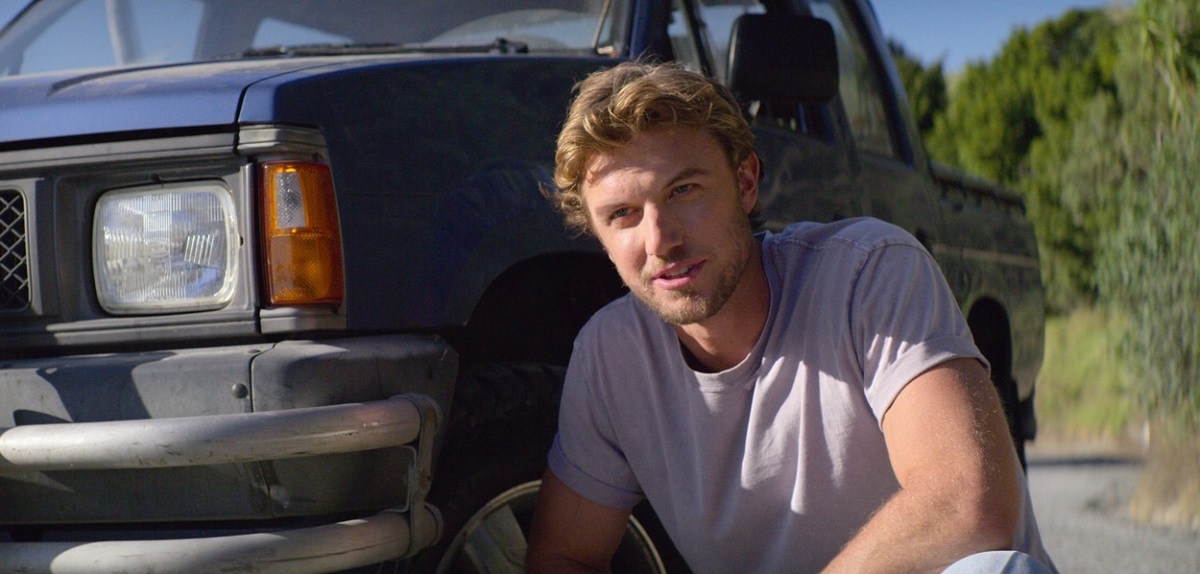 Adam în fața unei mașini în timp ce apare într-una din scenele din filmul Falling Inn Love