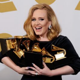 Adele și premiile sale Grammy la cea de-a 54-a ediție a evenimentului, în 2012. Artista a fost surprinsă pe covorul roșu cu numeroasele sale premii aurii, îmbrăcată într-o rochie neagră
