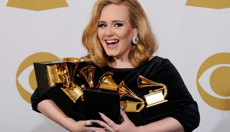 Adele și premiile sale Grammy la cea de-a 54-a ediție a evenimentului, în 2012. Artista a fost surprinsă pe covorul roșu cu numeroasele sale premii aurii, îmbrăcată într-o rochie neagră