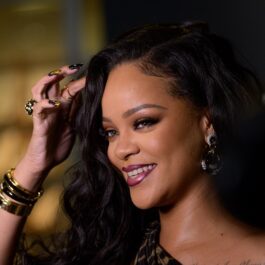 Portret al artistei Rihanna în timp ce își așează părul cu o mână încărcată de inele la lansarea autobiografiei din 2019