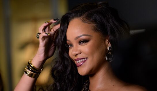 Portret al artistei Rihanna în timp ce își așează părul cu o mână încărcată de inele la lansarea autobiografiei din 2019