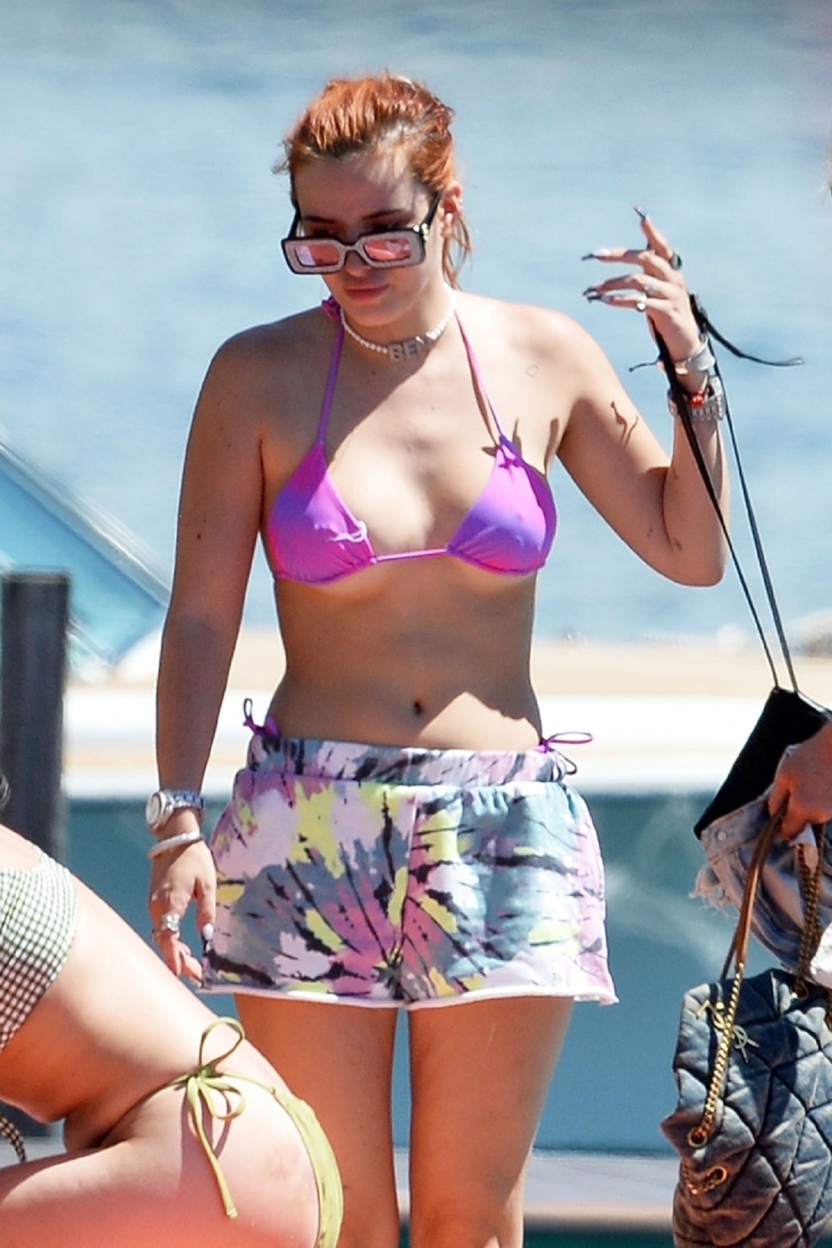 Bella Thorne sutien violet și o pereche de pantaloni scurți colorați în timp ce se află pe un vas de croazieră