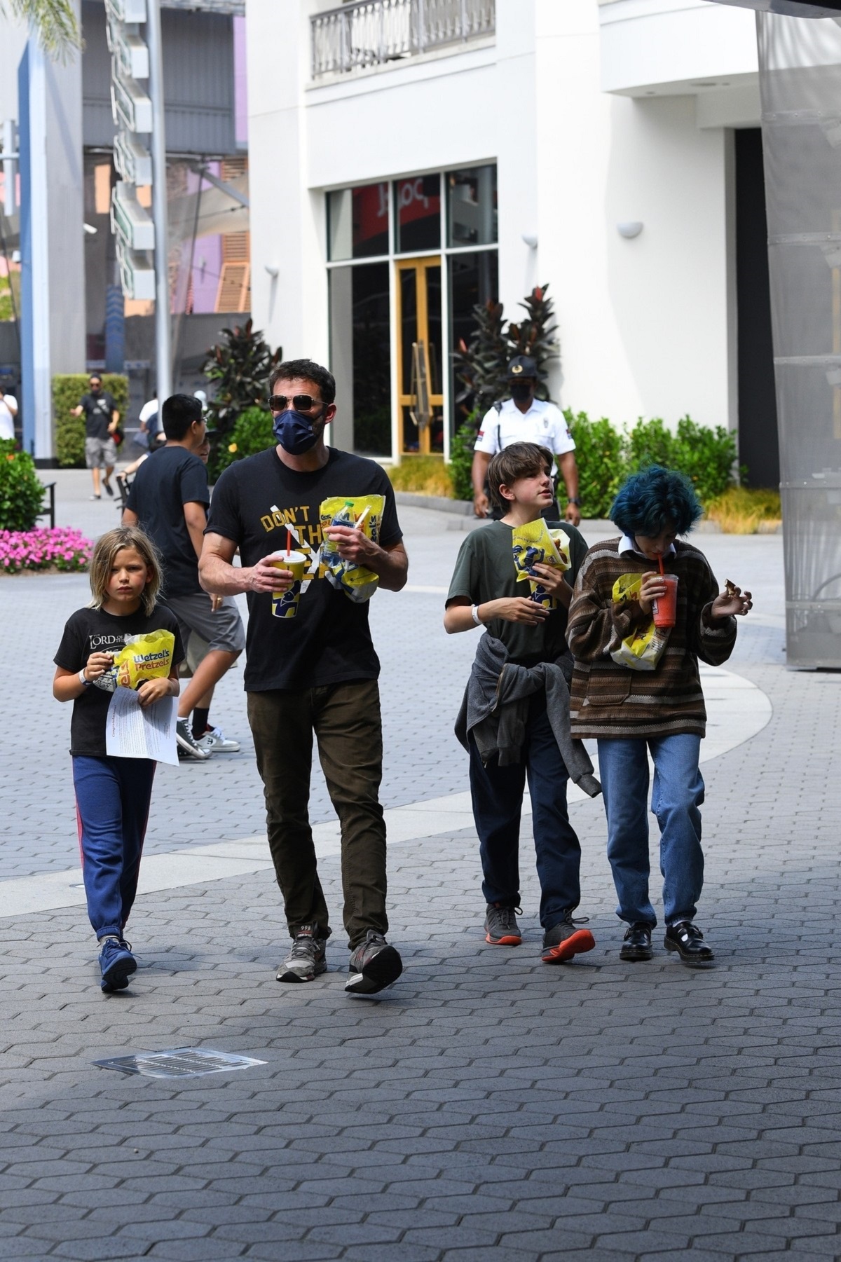 Ben Affleck cu mască pe față alături de copiii săi, Seraphine și Samuel și unul din copiii lui Jennifer Lopez Emme, în timp ce merg într-un parc tematic de distracții