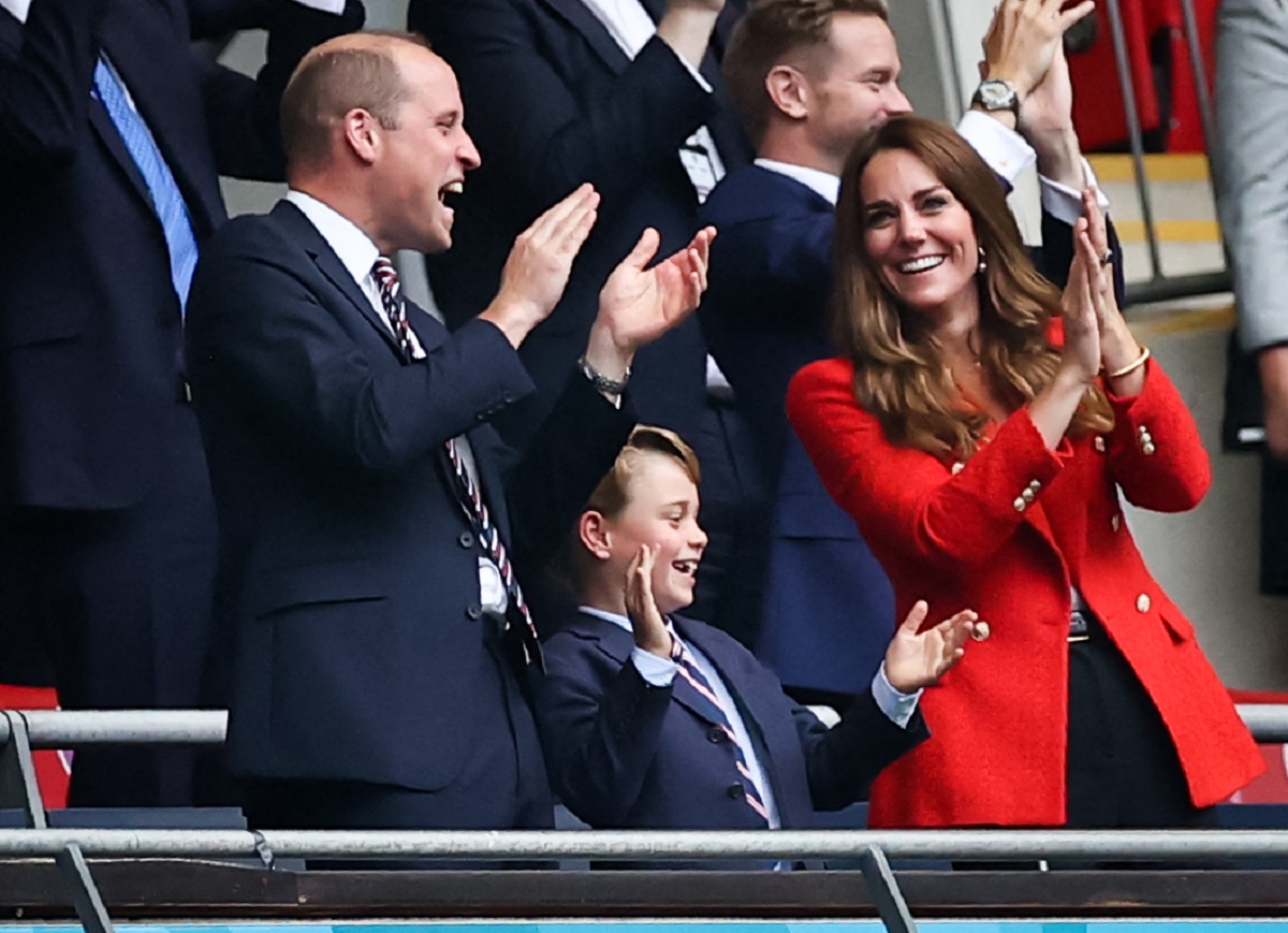 Prințul William alături de Prințul George care a purtat un costum elegant și Ducesa Kate Middleton în timp ce se află în tribuna unui stadion de fotbal și privesc un meci de la Euro 2020