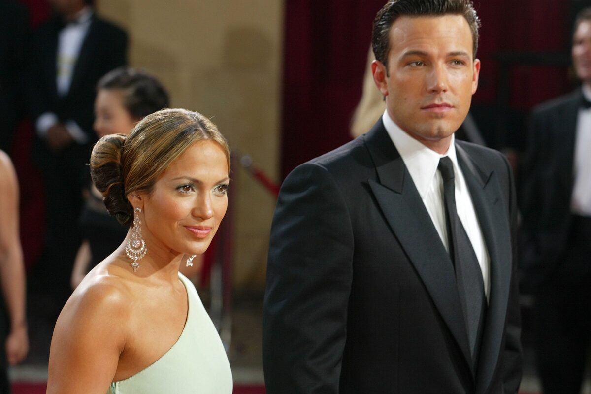 Jennifer Lopez într-o rochie albă în timp ce se află langa Ben Affleck la costum pe covorul roșu dovadă a faptului că sunt tot mai apropiați unul de celălalt
