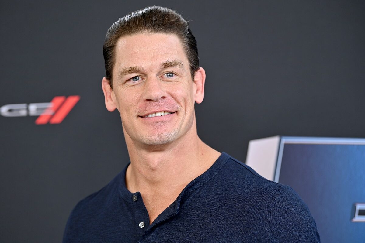 John Cena îmbrăcat într-un tricou albastru în timp ce zâmbește la cameră și își amintește că a dormit într-o mașină înainte să fie faimos