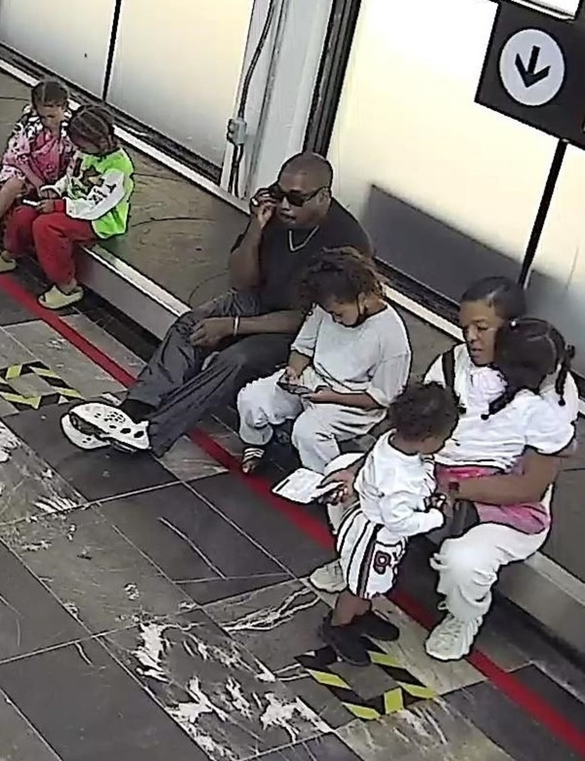 Kanye West în aeroportul din Mexic alături de cei patru copii ai săi în timp ce vorbește la telefon